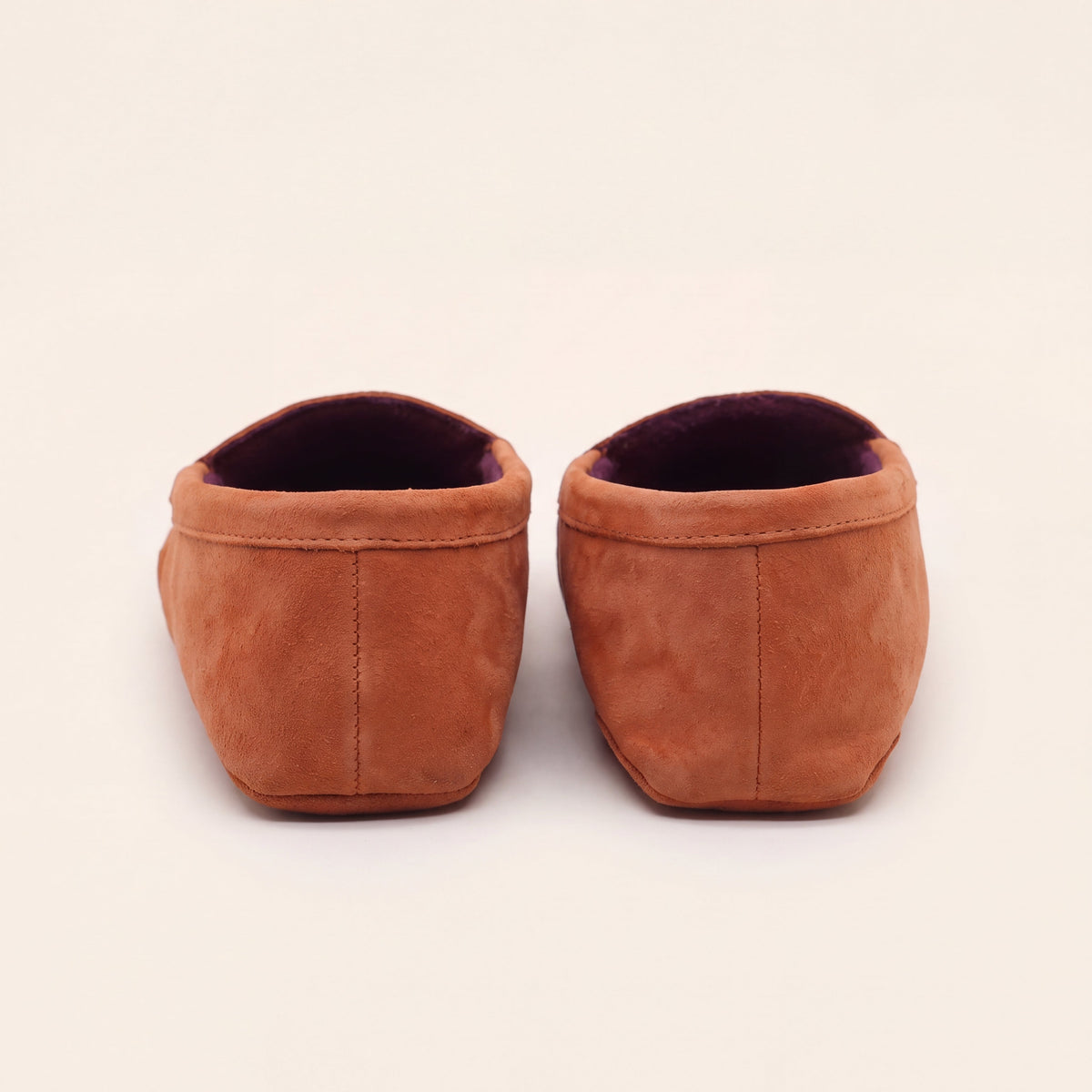 Heel and back stitching of coral suede slip-on moccasins with plum lining