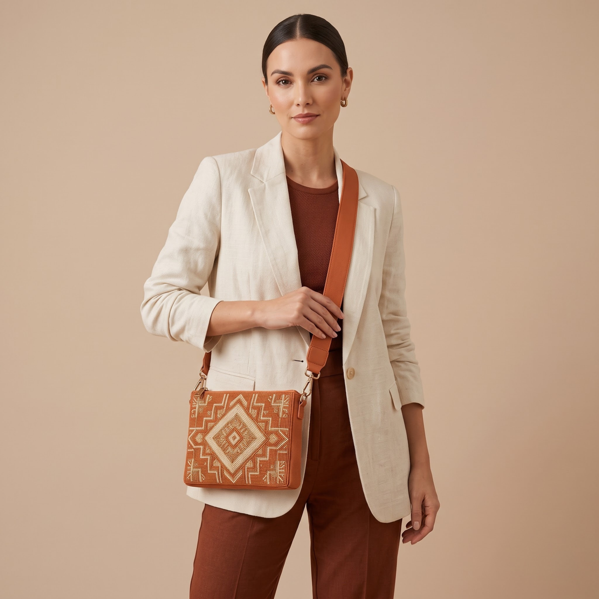 Rust geometric hand-beaded crossbody bag worn by model