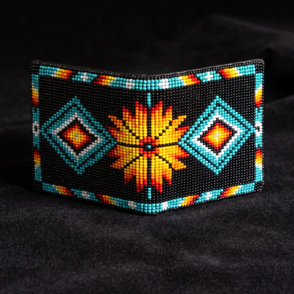 Black hand-beaded leather bifold wallet with turquoise diamond motifs and a large orange yellow sunburst center design