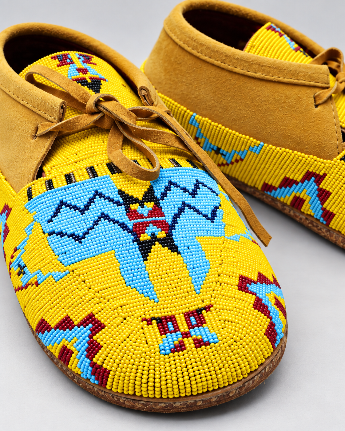 Close-up of yellow blue and red beadwork on men's suede moccasins