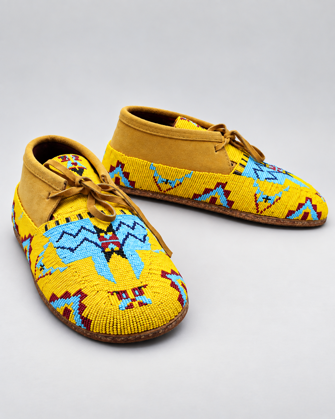 Side angle view of yellow hand-beaded men's moccasins