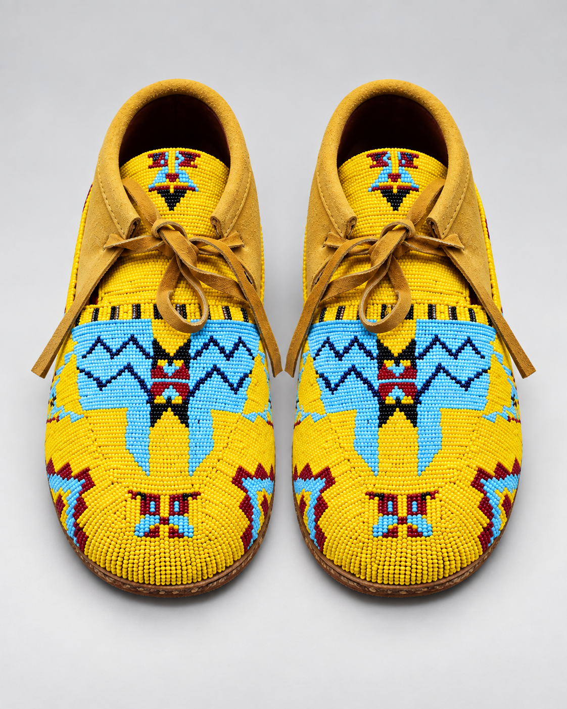 Top view of yellow hand-beaded men's moccasins with lace-up suede collar
